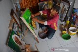 Teguh Trisnanto (40), menyelesaikan pembuatan lukisan dari bubur kertas di Mojongapit, Kabupaten Jombang, Jawa Timur, Kamis (14/11/2019). Lukisan berbahan bubur sampah kertas berbagai tema diantaranya tokoh ulama maupun pemadangan alam itu dipasarkan melalui media sosial dengan harga berkisar Rp700 ribu sampai jutaan rupiah. Antara Jatim/Syaiful Arif/zk