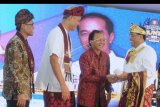 Menteri Perhubungan Budi Karya Sumadi (kanan) berjabat tangan dengan Gubernur Bali Wayan Koster (kedua kanan) disaksikan Ketua Umum PP Keluarga Alumni Universitas Gadjah Mada (Kagama) Ganjar Pranowo (kedua kiri) dan Rektor Universitas Gadjah Mada Panut Mulyono (kiri) saat pembukaan Munas XIII Kagama di Sanur, Denpasar, Bali, Jumat (15/11/2019). Munas XIII Kagama yang berlangsung 14-17 November itu mengusung tema 'Kagama Bersinergi untuk Indonesia Maju'. ANTARA FOTO/Fikri Yusuf/nym