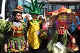 Sejumlah model mengenakan busana dengan atribut berbahan sayur dan buah-buahan saat Kampanye Makan Sayur di Serang, Banten, Jumat (15/11/2019). Acara tersebut digelar dalam menyambut Hari Kesehatan Nasional (HKN) sekaligus Kampanye Hidup Sehat. ANTARA FOTO/Asep Fathulrahman/nym.