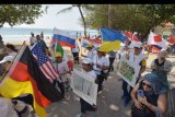 Peserta membawa bendera berbagai negara saat mengiringi obor perdamaian pada Parade Peace Run di Kuta, Badung, Bali, Sabtu (16/11/2019). Parade tersebut diikuti 13 negara untuk pertukaran kebudayaan dan berbagi pesan kedamaian, keharmonisan dan persahabatan. ANTARA FOTO/Nyoman Hendra Wibowo/nym.