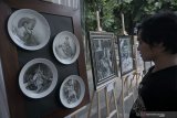 Pengunjung melihat-lihat lukisan pensil pada media piring keramik di pameran lukisan out door atau luar ruang bertajuk 