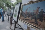 Pengunjung melihat-lihat karya seni perupa daerah dalam ajang pameran lukisan out door atau luar ruang bertajuk 