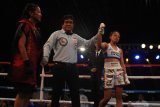 Wasit mengangkat tangan petinju wanita Singapura, Efasha Kamarudin (kanan) usai mengalahkan  petinju wanita Indonesia, Feti Rizqy Dwijayanti (kiri) dalam pertandingan tinju Internasional Mahkota Boxing Series di Batu, Jawa Timur, Minggu (17/11/2019). Dalam pertandingan tersebut Feti kalah angka dari Efasha. Antara Jatim/Ari Bowo Sucipto/zk.