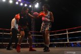 Petinju wanita Indonesia, Feti Rizqy Dwijayanti (kiri) berusaha memukul petinju wanita Singapura, Efasha Kamarudin (kanan) dalam pertandingan tinju Internasional Mahkota Boxing Series di Batu, Jawa Timur, Minggu (17/11/2019). Dalam pertandingan tersebut Feti kalah angka dari Efasha. Antara Jatim/Ari Bowo Sucipto/zk.