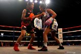 Petinju wanita Indonesia, Feti Rizqy Dwijayanti (kiri) berusaha memukul petinju wanita Singapura, Efasha Kamarudin (kanan) dalam pertandingan tinju Internasional Mahkota Boxing Series di Batu, Jawa Timur, Minggu (17/11/2019). Dalam pertandingan tersebut Feti kalah angka dari Efasha. Antara Jatim/Ari Bowo Sucipto/zk.