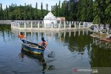 Pekerja menggunakan perahu memungut sampah plastik dikolam situs Taman Putroe Phang, Banda Aceh, Aceh, Senin (18/11/2019). Pembersihan sampah palstik bekas dan sampah lainnya di daerah aliran sungai situs Taman Putro Phang itu, merupakan gerakan bersih lingkungan yang dicanangkan pemerintah setempat dalam mewujudkan kota bersih, ramah lingkungan dan kota hijau. Antara Aceh/Ampelsa.