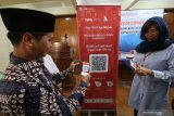 Kepala Tim Sistem Pembayaran Pengelolaan Uang Rupiah dan Layanan Administrasi, Nasrullah (kiri) melakukan scan Guick Response (QR) code kotak amal di Masjid Agung Kota Kediri, Jawa Timur, Selasa (19/11/2019). Bank Indonesia telah melakukan elektronofikasi kotak amal pada sedikitnya seribu rumah ibadah di Jawa Timur guna mempermudah masyarakat beramal sekaligus mendorong ekonomi syariah di Indonesia. Antara Jatim/Prasetia Fauzani/zk.