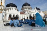 Sejumlah pelajar SD Islam Terpadu Alfityan School Kabupaten Aceh Besar belajar Alquran saat mengunjungi Masjid Raya Baiturrahman, Banda Aceh, Rabu (20/11/2019). Kegiatan belajar di alam terbuka memilih lokasi di halaman Masjid Raya Baiturrahman yang bertepatan dengan peringatan Hari Anak Sedunia itu merupakan program sehari bersama Alquran untuk memberikan nuansa baru bagi anak sekolah. Antara Aceh/Ampelsa.