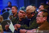 Gubernur Jawa Barat Ridwan Kamil (kiri) berbincang dengan Ketua Bawaslu Jabar Abdullah Dahlan (tengah) saat acara peluncuran pengawasan pilkada serentak di Bandung, Jawa Barat, Rabu (20/11/2019). Peluncuran tersebut merupakan bagian dari Bawaslu untuk menginformasikan kepada seluruh masyarakat bahwa pelaksanaan pengawasan pemilu di tujuh Kabupaten dan satu Kota di Jawa Barat telah dimulai dan akan dilaksanakan pada 23 September 2020 mendatang. ANTARA FOTO/Raisan Al Farisi/agr