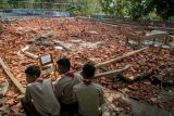 Pelajar melihat reruntuhan bangunan aula sekolah yang roboh di SMK Negeri I Miri, Sragen, Jawa Tengah, Kamis (21/11/2019). Bangunan aula sekolah tersebut roboh akibat hujan dan angin kencang yang menyebabkan 22 siswa mengalami luka-luka karena tertimpa reruntuhan bangunan. ANTARA FOTO/Mohammad Ayudha/nym.