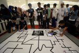 Peserta menguji robotnya dalam melintasi garis saat mengikuti International Robotics Competition 2019 kategori 