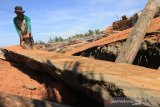 Seorang warga membelah kayu bekas sampah laut di pinggir pantai Desa Peunaga Cut Ujong, Kecamatan Meureuboe, Aceh Barat, Aceh, Sabtu (23/11/2019). Kayu bekas sampah laut yang hanyut dari sisa banjir tersebut diolah dan dijual ke tempat penampung, dengan harga Rp100.000 sampai Rp700.000. Antara Aceh/Syifa Yulinnas.