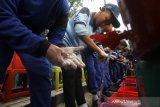 Sejumlah siswa mengikuti aksi cuci tangan saat peringatan Hari Kesehatan Nasional ke-55 di Siring Tugu 0 Km Banjarmasin, Kalimantan Selatan, Minggu (24/11/2019). Hari Kesehatan Nasional ke-55 tahun 2019 di Kalsel diisi berbagai kegiatan seperti aksi Cuci Tangan yang diikuti oleh ratusan siswa SMP di Banjarmasin, Jalan Sehat dan pemecahan rekor MURI pembagian sayuran dan buah dari jukung. Foto Antaranews Kalsel/Bayu Pratama S.