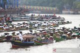 Sejumlah pedagang pasar terapung melakukan atraksi jukung berenteng di sungai Martapura, Banjarmasin, Kalimantan Selatan, Minggu (24/11/2019). Sebanyak 374 pedagang pasar terapung berhasil memecahkan Rekor Museum Indonesia (MURI) sebagai rekor pembagian sayuran dan buah dari jukung terbanyak. Foto Antaranews Kalsel/Bayu Pratama S.