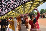 Peserta membentangkan kain batik saat parade 1.000 meter batik di Gelora A Yani Kota Mojokerto, Jawa Timur, Minggu (24/11/2019). Parade 1.000 meter batik itu merupakan rangkaian event Mojo Spekta 2019 yang digelar selama 5 hari, untuk mengangkat pariwisata serta mengenalkan batik khas Kota Mojokerto. Antara Jatim/Syaiful Arif/zk.