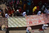 Peserta membentangkan kain batik saat parade 1.000 meter batik di Gelora A Yani Kota Mojokerto, Jawa Timur, Minggu (24/11/2019). Parade 1.000 meter batik itu merupakan rangkaian event Mojo Spekta 2019 yang digelar selama 5 hari, untuk mengangkat pariwisata serta mengenalkan batik khas Kota Mojokerto. Antara Jatim/Syaiful Arif/zk.