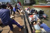 Warga bersama relawan memindahkan logistik bantuan dari perahu bermesin di dermaga desa Sungai Bali, Kecamatan Pulau Sebuku, Kabupaten Kotabaru, Kalimantan Selatan, Senin (25/11/2019). Bantuan logistik berupa beras, makanan instan dan pakaian layak pakai dari berbagai instansi baik pemerintah daerah maupun perusahaan serta relawan terus mengalir untuk meringankan korban kebakaran di desa Sungai Bali Kecamatan Pulau Sebuku. Foto Antaranews Kalsel/Bayu Pratama S.