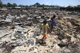 Anak-anak bermain di puing-puing rumah yang hangus terbakar di desa Sungai Bali, Kecamatan Pulau Sebuku, Kabupaten Kotabaru, Kalimantan Selatan, Senin (25/11/2019). Kebakaran yang terjadi pada Sabtu (23/11/2019) malam tersebut menghanguskan 200 rumah, dua los pasar, satu buah kantor Polsek, lima pintu Asrama Polisi dan satu Mushala, mengakibatkan 750 jiwa mengungsi. Foto Antaranews Kalsel/Bayu Pratama S.