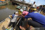 Warga bersama relawan memindahkan logistik bantuan dari perahu bermesin di dermaga desa Sungai Bali, Kecamatan Pulau Sebuku, Kabupaten Kotabaru, Kalimantan Selatan, Senin (25/11/2019). Bantuan logistik berupa beras, makanan instan dan pakaian layak pakai dari berbagai instansi baik pemerintah daerah maupun perusahaan serta relawan terus mengalir untuk meringankan korban kebakaran di desa Sungai Bali Kecamatan Pulau Sebuku. Foto Antaranews Kalsel/Bayu Pratama S.