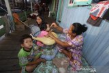 Warga mengungsi di rumah bedakan pasca kebakaran yang melanda desa Sungai Bali, Kecamatan Pulau Sabuku, Kabupaten Kotabaru, Kalimantan Selatan, Senin (25/11/2019). Pasca kebakaran yang melanda kawasan tersebut pada Sabtu (23/11/2019) malam, sebanyak 104 Kepala Keluarga, 750 jiwa mengungsi di rumah tetangga dan tenda darurat akibat kehilangan tempat tinggal. Foto Antaranews Kalsel/Bayu Pratama S.