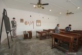 Warga mengamati koleksi Museum Pendidikan di Jalan Genteng Kali, Surabaya, Jawa Timur, Senin (25/11/2019). Museum yang berdiri di bekas bangunan Sekolah Taman Siswa dan menyimpan benda bersejarah tentang pendidikan dari masa ke masa itu diresmikan oleh Wali Kota Surabaya Tri Rismaharini tepat di Hari Guru yang jatuh pada hari ini. Antara Jatim/Didik S/ZK