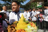 Pelajar membawa tumbeng utuk diberikan kepada guru seusai upacara peringatan hari guru nasional dan HUT Persatuan Guru Republik Indonesia (PGRI) di MTsN Model, Banda Aceh, Aceh, Senin (25/11/2019). Peringatan hari guru nasional yang bertepatan dengan HUT ke-74 Persatuan Guru Republik Indonesia (PGRI) menjadi momentum memberikan penghargaan dan ungkapan terima kasih kepada guru yang telah mendidik serta meningkatkan kualitas sumber daya manusia generasi penerus pembangunan bangsa. Antara Aceh/Irwansyah Putra.