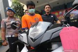 Polisi memperlihatkan tersangka begal payudara berinisial SP (tengah) berikut barang bukti berupa sepeda motor saat gelar kasus cabul di Polres Kediri, Jawa Timur, Rabu (27/11/2019). Tersangka mengaku telah tiga kali melakukan aksi cabul tersebut dengan mengendarai sepeda motor dan meremas payudara korbannya di jalan raya. Antara Jatim/Prasetia Fauzani/zk.