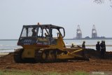 Pekerja menggunakan alat berat untuk pelaksanaan pemulihan (restorasi) garis pantai proyek kilang minyak 