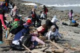 Warga dari Global Peace Youth Indonesia memunguti sampah yang berserakan di pantai di kawasan Tambak Wedi, Surabaya, Jawa Timur, Minggu (1/12/2019). Aksi bersih-bersih pantai dari sampah plastik itu merupakan bentuk kepedulian terhadap lingkungan. Antara Jatim/Didik/ZK