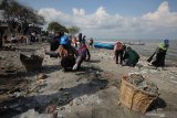 Warga dari Global Peace Youth Indonesia memunguti sampah yang berserakan di pantai di kawasan Tambak Wedi, Surabaya, Jawa Timur, Minggu (1/12/2019). Aksi bersih-bersih pantai dari sampah plastik itu merupakan bentuk kepedulian terhadap lingkungan. Antara Jatim/Didik/ZK