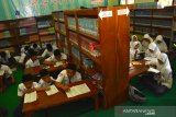 Siswa kelas 3 mengikuti proses belajar secara lesehan di ruang perpustakaan MTs Negeri 12 Desa Nglele, Kecamatan Sumobito, Jombang, Jawa Timur, Senin (2/12/2019). Sambil menunggu perbaikan ruang kelas yang rusak akibat diterjang angin kencang, proses kegiatan belajar mengajar siswa kelas 3 MTs Negeri 12 Jombang terpaksa dipindahkan sementara ke ruang perpustakaan. Antara Jatim/Syaiful Arif/zk.