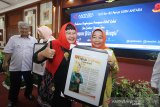 Direktur Keuangan, MSDM dan Umum Perum LKBN Antara Nina Kurnia Dewi (kiri) memberikan penghargaan sang Inspirator perempuan Kalsel kepada Kepala Dinas Pengendalian penduduk dan Keluarga Berencana Daerah(DPPKBD) Kabupaten Hulu Sungai Utara (HSU) Anisah Rasyidah Wahid (kanan) saat acara Penghargaan Perempuan Hebat Kalsel dan Seminar 