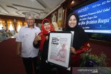Direktur Keuangan, MSDM dan Umum Perum LKBN Antara Nina Kurnia Dewi (kiri) memberikan penghargaan kepada Perempuan Hebat Kalsel terpilih saat acara Penghargaan Perempuan Hebat Kalsel dan Seminar 
