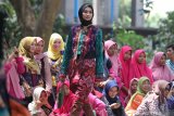 Model memperagakan busana berbahan kain tenun ikat khas Kediri pada Dhoho Street Fashion di Taman Hutan Joyoboyo, Kota Kediri, Jawa Timur, Kamis (5/12/2019). Peragaan busana dengan tema Pride of Jayabaya tersebut menghadirkan sejumlah desainer lokal dan nasional. Antara Jatim/Prasetia Fauzani/zk.