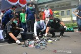 Kajari Jombang, Syafiruddin (kanan), Kasatreskoba Polres Jombang AKP Mukid (kiri) melakukan pemusnahan barang bukti narkotika berupa handphone dengan cara dirusak sebelum dibakar di Kejaksaan Negeri Jombang, Jawa Timur, Jumat (6/12/2019). Kejari Jombang memusnahkan barang bukti tindak pidana narkotika sebanyak 305,78 gram sabu, 96,35 gram ekstasi, 120.242 butir pil dobel L, dan ratusan handphone berbagai merk yang telah memiliki kekuatan hukum tetap. Antara Jatim/Syaiful Arif/zk