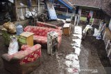 Warga membersihkan perabotan rumah tangga yang terkena lumpur pascabanjir bandang di Kertasari, Kabupaten Bandung, Jawa Barat, Sabtu (7/12/2019).  Sedikitnya 20 rumah dan lahan pertanian di kawasan tersebut mengalami kerusakan serta terendam lumpur akibat banjir bandang yang terjadi pada Jumat (6/12) lalu. ANTARA JABAR/Novrian Arbi/agr