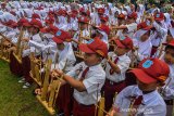 Sejumlah siswa Sekolah Dasar Negeri (SDN) se-Kota Tasikmalaya memainkan angklung dalam rangka memeriahkan hari angklung sedunia (Angklung Day) yang ke-9 di Balekota Tasikmalaya, Jawa Barat, Senin (9/12/2019). Memainkan angklung massal yang diikuti 2019 siswa bertujuan agar generasi penerus tidak melupakan kesenian musik tradisional dan diharapkan bisa mempertahankan serta mengembangkan kesenian angklung dari upaya pelestarian kearifan lokal. ANTARA JABAR/Adeng Bustomi/agr