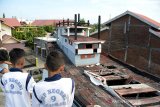 Pelajar berada di anjungan saat menyaksikan situs Kapal Tsunami Atas Rumah, di Desa Lampulo, Banda Aceh, Aceh, Rabu (11/12/2019). Menjelang peringatan 15 tahun Tsunami Aceh, 26 Desember , sejumlah situs tsunami di daerah itu tidak terawat, salah satunya objek wisata kapal nelayan yang terdampar di atas rumah penduduk pada bagian lantai kapal tusak dan berlubang karena kurangnya perhatian dari pemerintah setempat . Antara Aceh/Ampelsa.
