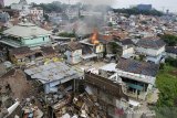 Sebuah rumah terbakar ketika terjadi bentrokantara warga dengan petugas saat pengosongan lahan dan pengamanan lahan RW 11 Tamansari, Bandung, Jawa Barat, Kamis (12/12/2019). Eksekusi lahan pemukiman warga RW 11 Tamansari yang dilakukan Petugas Gabungan Satpol PP, TNI dan Polisi untuk percepatan Proyek Rumah Deret tersebut ricuh dan dihadang warga karena dianggap masih menunggu putusan PTUN dalam kepemilikan tanah. ANTARA JABAR/Novrian Arbi/agr