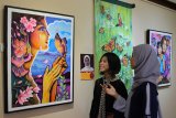 Pengunjung mengamati lukisan yang dipajang pada pameran bertema 'MOMiracle' di Galeri Paviliun, House of Sampoerna, Surabaya, Jawa Timur, Rabu (11/12/2019). Sebanyak 34 lukisan karya 34 perupa wanita yang tergabung dalam Ikatan Wanita Pelukis Indonesia (IWPI) ditampilkan dalam pameran yang berlangsung sampai 11 Januari 2020. Antara Jatim/Didik/ZK