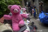 Seorang anak membawa boneka miliknya saat penggusuran permukiman Tamansari, Bandung, Jawa Barat, Kamis (12/12/2019). Upaya penggusuran tersebut berakhir ricuh setelah Satpol PP memaksa warga dan aktivis mahasiswa untuk mengosongkan tempat tinggalnya di lahan sengketa yang dimana proses sidang sengketa lahan masih berlangsung di PTUN Bandung. ANTARA JABAR/Raisan Al Farisi/agr