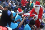 Relawan dengan mengenakan kostum Santaclaus membagikan makanan secara gratis kepada anak-anak dalam kegiatan Sarapan Bersama Santa di halaman Malang Town Square, Malang, Jawa Timur, Kamis (12/12/2019). Kegiatan yang diikuti ratusan siswa TK tersebut diadakan untuk memeriahkan Natal. Antara Jatim/Ari Bowo Sucipto/zk