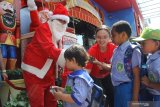 Relawan dengan mengenakan kostum Santaclaus membagikan hadiah kepada anak-anak dalam kegiatan Sarapan Bersama Santa di halaman Malang Town Square, Malang, Jawa Timur, Kamis (12/12/2019). Kegiatan yang diikuti ratusan siswa TK tersebut diadakan untuk memeriahkan Natal. Antara Jatim/Ari Bowo Sucipto/zk