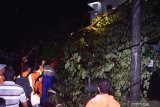 Petugas membersihkan pohon tumbang yang menutup jalan akibat angin kencang di kawasan Stasiun Kereta Api di Kota Madiun, Jawa Timur, Jumat (13/12/2019) malam. Bencana angin kencang mengakibatkan sejumlah pohon tumbang dan bangunan rusak. Antara Jatim/Siswowidodo/zk