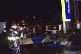 Wartawan mengambil gambar reruntuhan bagian depan bangunan gedung Bank Mandiri yang rusak akibat angin kencang di Kota Madiun, Jawa Timur, Jumat (13/12/2019) malam. Bencana angin kencang mengakibatkan sejumlah pohon tumbang dan bangunan rusak. Antara Jatim/Siswowidodo/zk