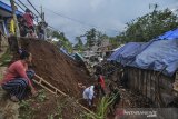 Warga membersihkan meterial tanah longsor menimpa rumah warga di Kampung Cimanggala, Kawalu, Kota Tasikmalaya, Jawa Barat, Senin (16/12/2019). Curah hujan yang tinggi didaerah tersebut mengakibatkan satu rumah tertimbun tanah longsor dan tidak ada korban jiwa dalam peristiwa tersebut. ANTARA JABAR/Adeng Bustomi/agr