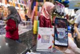 Pembeli melakukan transaksi pembayaran digital dengan barcode di Pasar Baru, Bandung, Jawa Barat, Senin (16/12). Bank BJB meluncurkan pembayaran digital dengan menggunakan Quick Response Code Indonesian Standard (QRIS), bjb EDC berbasis Android dan bjb Digi (mobile banking) yang bertujuan untuk mendukung interkoneksi instrumen sistem pembayaran yang lebih luas dan mengakomodasi kebutuhan transaksi keuangan secara nasional. ANTARA JABAR/M Agung Rajasa/agr