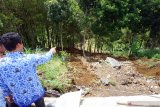 Petugas memeriksa kondisi plengseng jalan yang amblas terseret longsor di jalur menuju lereng Gunung Wilis, Desa Geger, Tulungagung, Jawa Timur, Selasa (17/12/2019). Plengseng jalan di jalur Selingkar Wilis itu amblas terseret longsor akibat hujan deras yang mengguyur wilayah tersebut, sehari sebelumnya. Antara Jatim/Destyan Sujarwoko/zk.