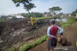 Warga menyaksikan pekerja yang mengoperasikan alat berat pada proyek normalisasi Sungai Citarum di Oxbow Sapan, Kabupaten Bandung, Jawa Barat, Selasa (17/12/2019). Normalisasi tersebut dilakukan dalam rangka penataan terpadu Daerah Aliran Sungai Citarum untuk menangani pencemaran dan kerusakan lingkungan yang mengakibatkan kerugian di bidang kesehatan, ekonomi, sosial, ekosistem, dan sumber daya lingkungan. ANTARA JABAR/Raisan Al Farisi/agr