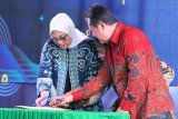 Menteri Tenaga Kerja, Ida Fauziyah (kiri) dan  Wakil Menteri Pertahanan, Wahyu Sakti Trenggono (kanan) menandatangani nota kesepahaman dalam Peringatan Hari Buruh Migran di GOR Vira Yudha Markas Divisi Infanteri 2 Kostrad, Singosari, Malang, Jawa Timur, Rabu (18/12/2019). Kegiatan tersebut juga sekaligus menandai kerjasama Kementerian Tenaga Kerja dan kementerian Pertahanan dalam upaya mendorong Tenaga Kerja Indonesia (TKI) untuk menjadi duta bela negara yakni dengan memasukkan kurikulum bela negara dalam pelatihan bagi calon TKI yang akan keluar negeri. Antara Jatim/Ari Bowo Sucipto/zk.